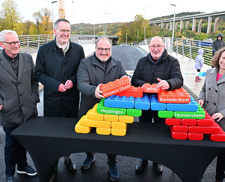 Vertreter der Stadt feiern die Eröffnung mit bunten Bausteinen.
