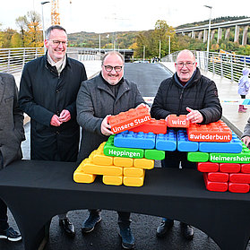 Vertreter der Stadt feiern die Eröffnung mit bunten Bausteinen.