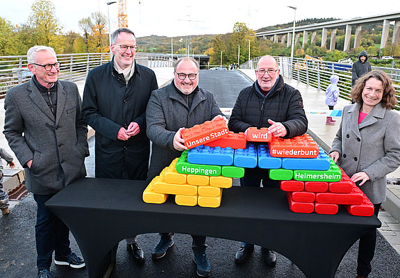 Vertreter der Stadt feiern die Eröffnung mit bunten Bausteinen.