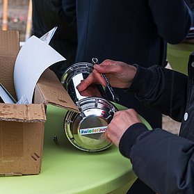 Eine Zeitkapsel wird befüllt während der Grundsteinlegung im März 2026.