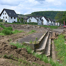 Baustelle des neuen Feuerwehrhauses im Stadtteil Ahrweiler mit Baugeräten und Häusern im Hintergrund.