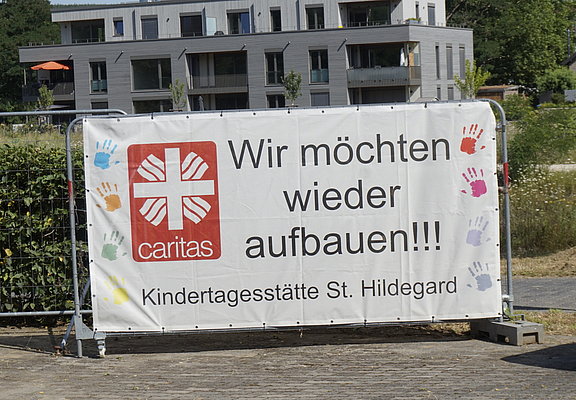 Baustelle der Kita St. Hildegard in Bad Neuenahr mit Banner „Wir möchten wieder aufbauen“ im Stadtteil Bad Neuenahr.