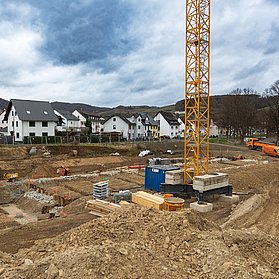 Baustelle des neuen Feuerwehrhauses im Stadtteil Ahrweiler mit Kran und Baumaterial in städtischer Umgebung.