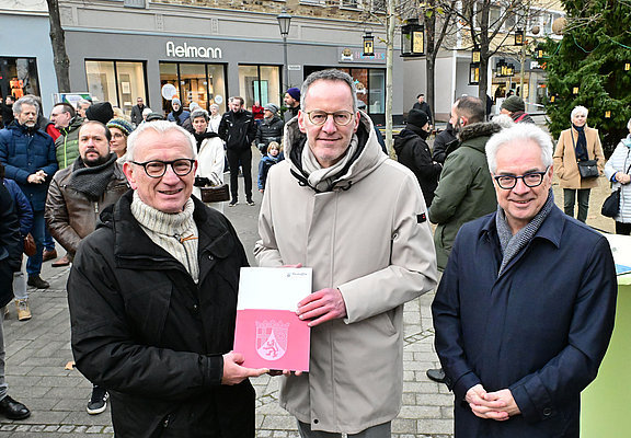 Personen bei der Übergabe eines Dokuments in der Innenstadt