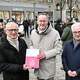 Personen bei der Übergabe eines Dokuments in der Innenstadt