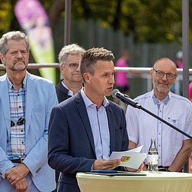 Der Bürgermeister hält eine Begrüßungsrede umgeben von Vertretern der Stadt und der Sportvereine