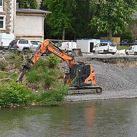 Bauarbeiten an der Carl-von-Ehrenwall-Allee im Stadtteil Ahrweiler mit Bagger und Materialtransport am Flussufer.