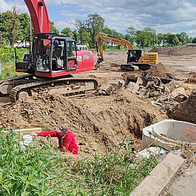 Baustelle des neuen Feuerwehrhauses im Stadtteil Ahrweiler mit Baggern und Bauarbeitern in Aktion.