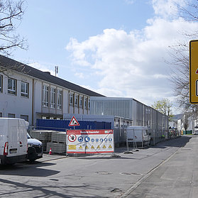 Container und Baumaterialen vor dem Altbau der Grundschule Bad Neuenahr.