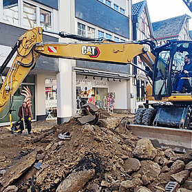 Bagger schaufelt Erde auf der Baustelle in der Niederhut mit begehbarem Streifen an der Seite
