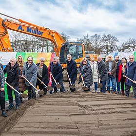 Vertreter der Stadt eröffnen die Baumaßnahme mit dem Spatenstich, indem sie alle Erde auf die Baustelle schaufeln.